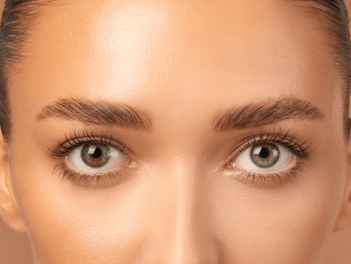 Professional beauty therapist shaping a client’s eyebrow with wax during a brow definition treatment in Weymouth