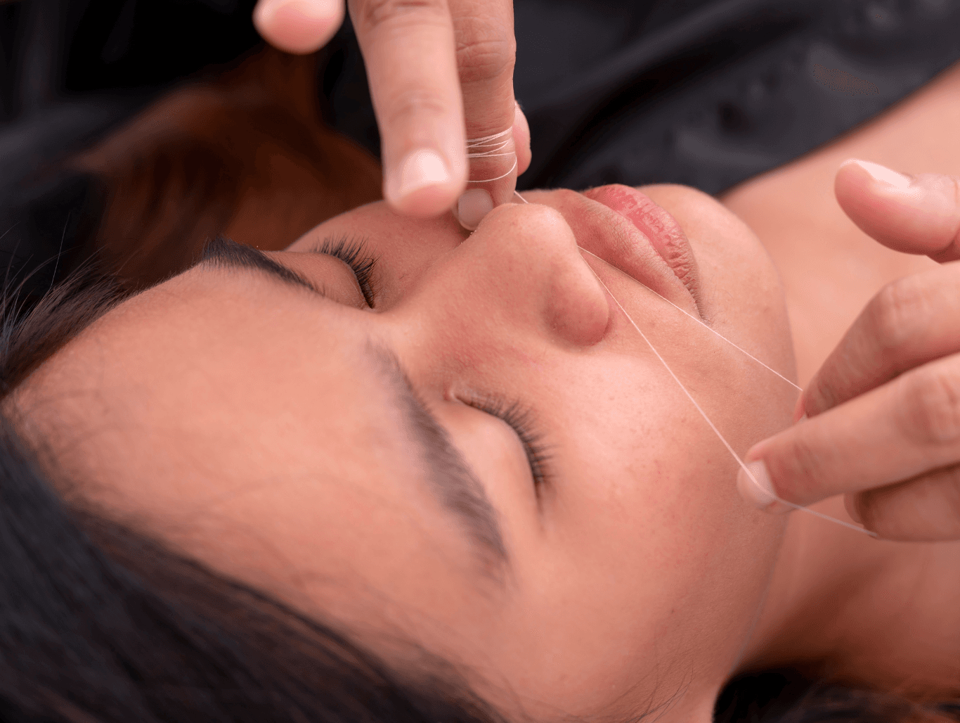 Close-up of a client receiving full face threading treatment at Changing Grooms in Weymouth, gently removing facial hair for smooth, polished skin.