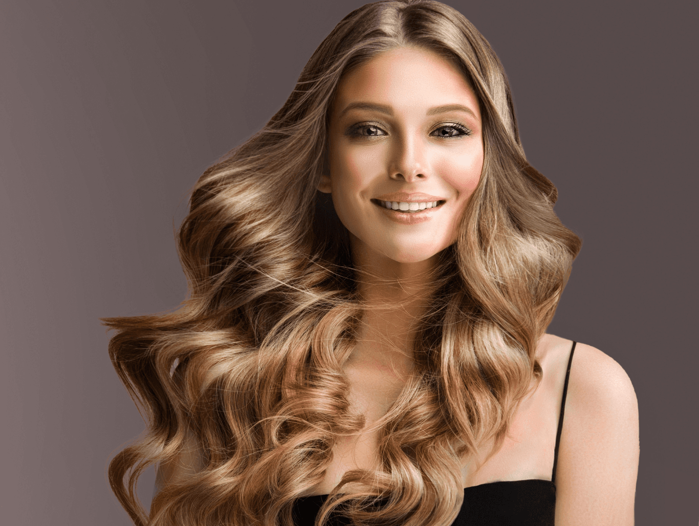 Smiling woman with multi-tonal blonde hair from full head highlights and root colour, styled with soft curls in a Weymouth salon