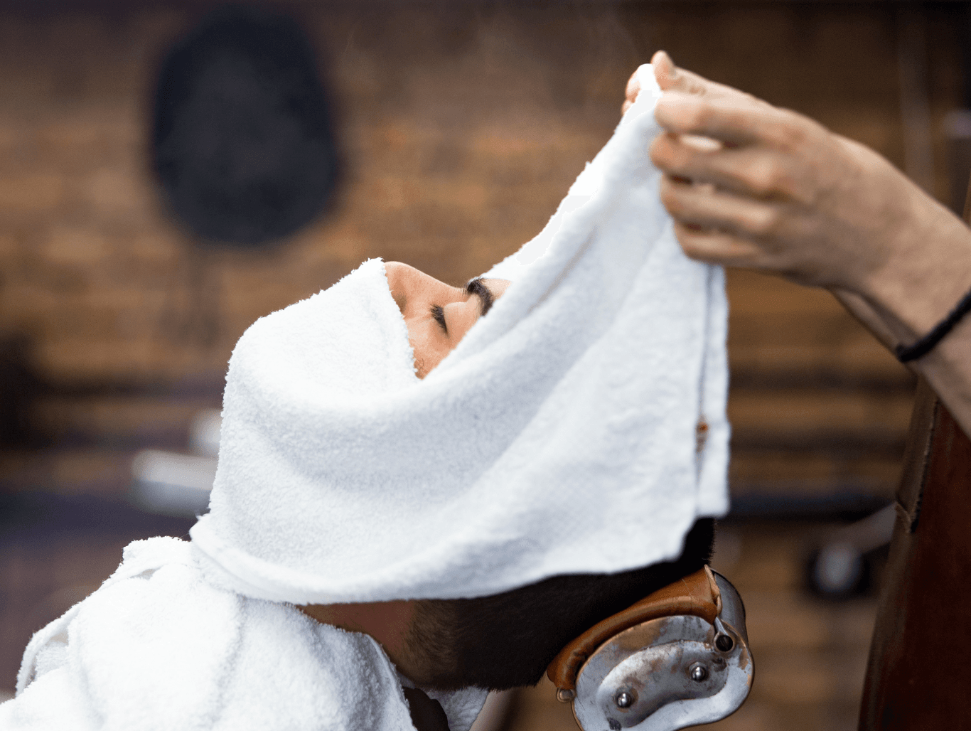Client receiving a hot towel wrap as part of a luxury facial treatment at a Weymouth barbershop