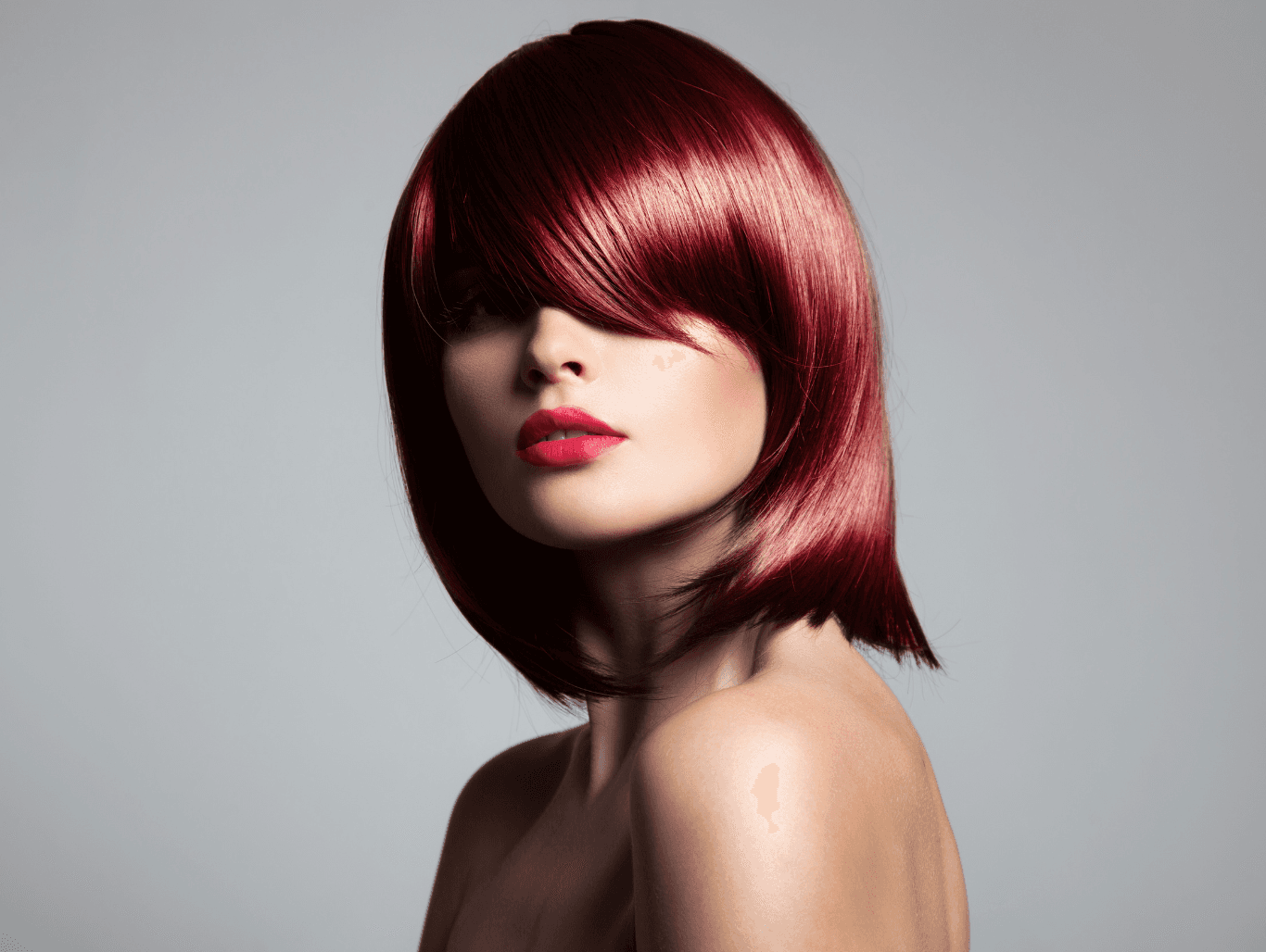 Model with vibrant red hair colour showing freshly tinted roots after a salon root tint in Weymouth