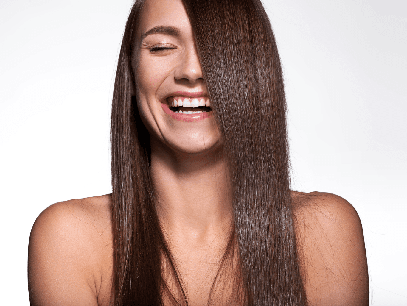 Smiling woman with glossy, straight brunette hair after a semi colour at a Weymouth hair salon