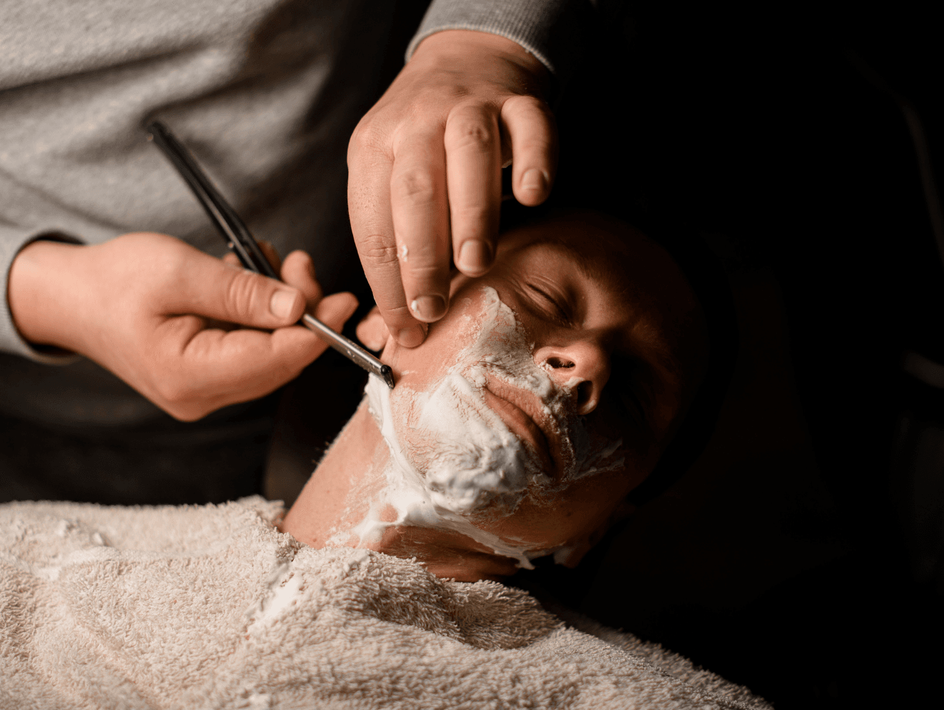 Man receiving a hot towel traditional wet shave with cut-throat razor at a professional Weymouth barbershop
