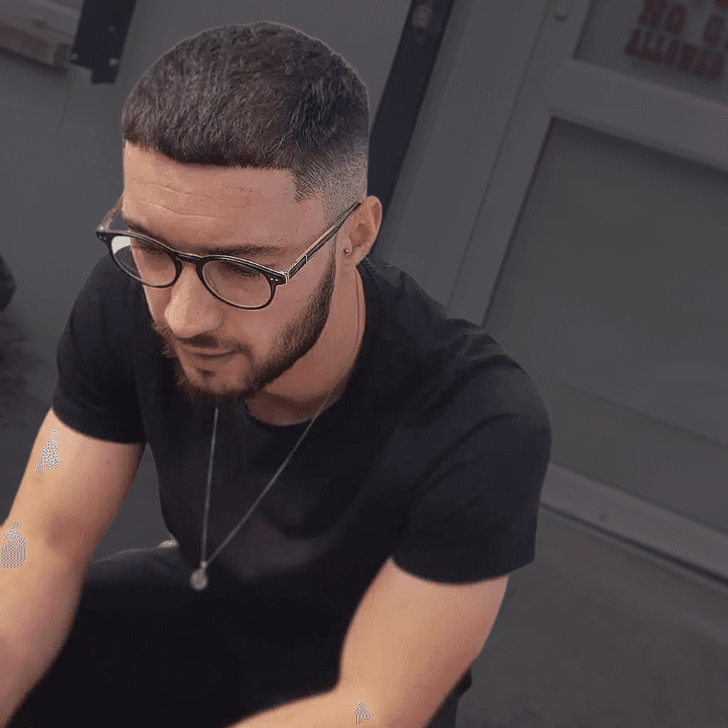 Man with a precise 0.5 zero fade and longer top, styled after shampoo, scalp massage, and tonic at a Weymouth barber